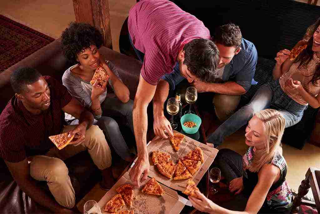 group of people sharing a pizza