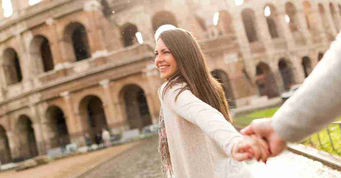 a smiling girl holding hand in front coloseum rome - 3 days in rome