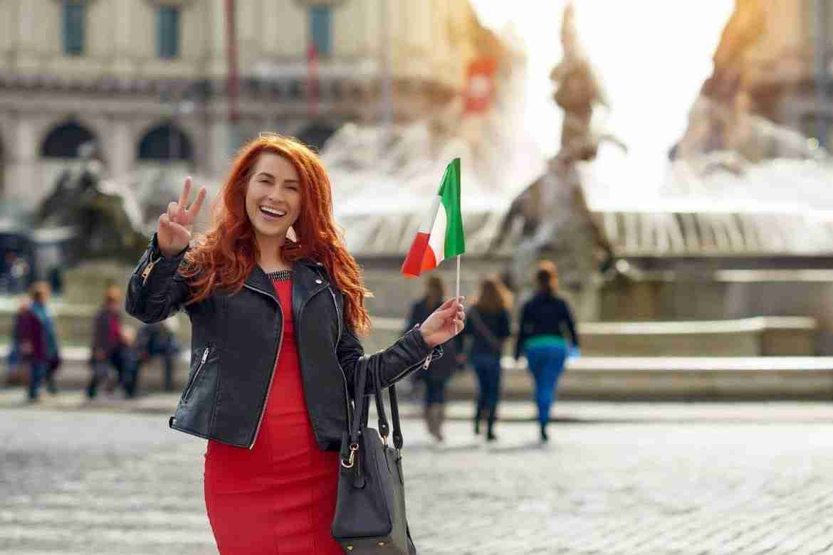 smiling girl with red hair and italianflag doing v sign Italian habits