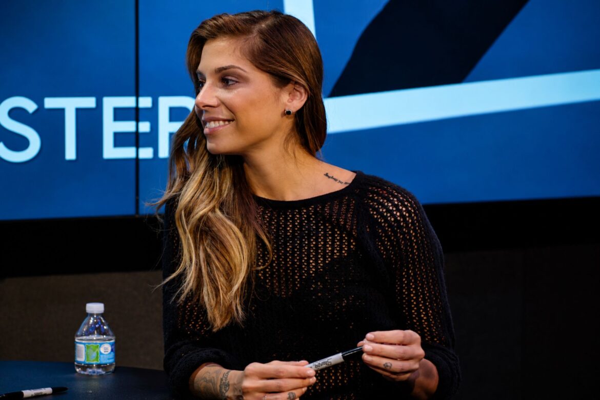 Christina Perri smiling during a public appearance while holding a marker