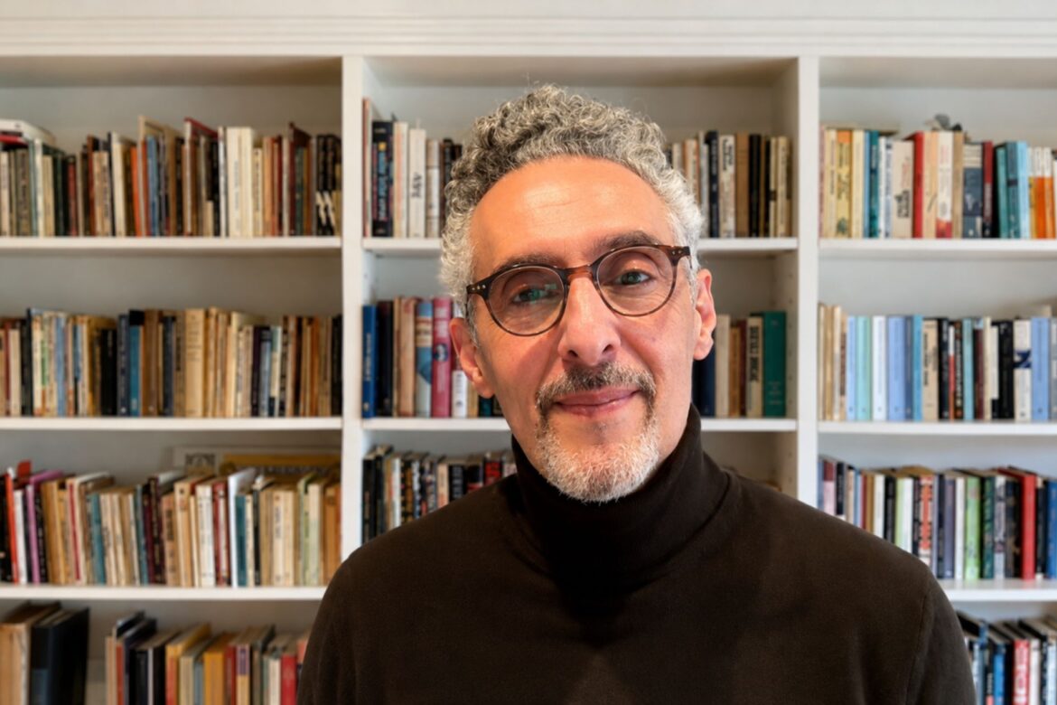 John Turturro, Italian-American actor and director, in front of a bookshelf